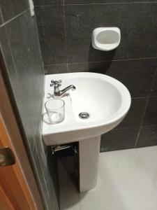 a white sink in a bathroom with black walls at The Soul Center in Batuan