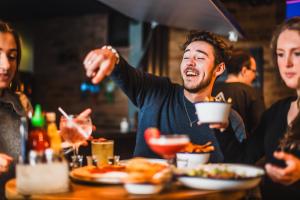 Un gruppo di persone seduti intorno a un tavolo che mangiano cibo di St Christopher's Inn Village - London Bridge a Londra