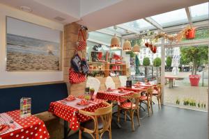 ein Restaurant mit roten und weißen Polka-Punkten-Tischen und Stühlen in der Unterkunft Hotel Aan Zee in De Panne