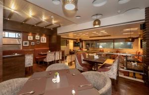 a restaurant with tables and chairs and a bar at Hotel Le Grande - Mumbai International Airport in Mumbai