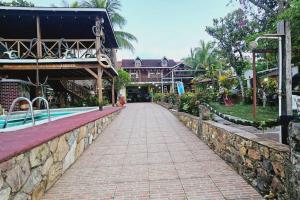 a walkway next to a resort with a swimming pool at Chalet Villarrué, Izabalito in Izabal
