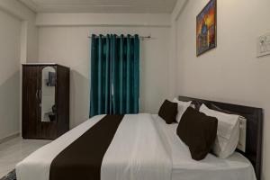 OYO Flagship Hotel Aanandwan Palace في فاراناسي: غرفة نوم بسرير كبير وستارة زرقاء