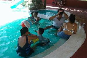 a group of people sitting in a swimming pool at Chalet Villarrué, Izabalito in Izabal