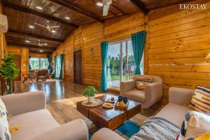 een woonkamer met houten wanden en houten vloeren bij EKOSTAY Luxe - Woodstock Villa I 2 Acre Property I Cricket Turf I Party Friendly in Karjat