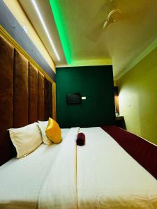sypialnia z dużym białym łóżkiem i zieloną ścianą w obiekcie RAGAM RESORT w mieście Alappuzha