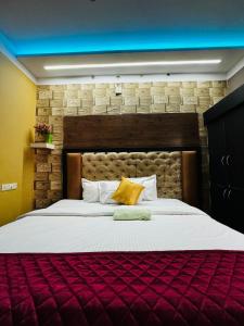 een slaapkamer met een groot bed met een bakstenen muur bij RAGAM RESORT in Alleppey