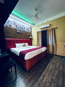 um quarto com uma cama grande e uma cabeceira vermelha em RAGAM RESORT em Alappuzha