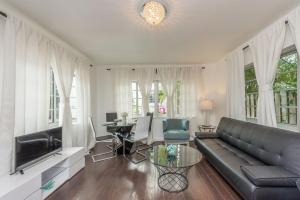 a living room with a leather couch and a table at Casa Gaby Apartments Part of the Oasis Casita Collection in Miami Beach