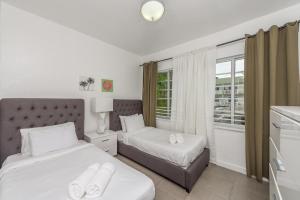 a bedroom with two beds and a window at Casa Gaby Apartments Part of the Oasis Casita Collection in Miami Beach