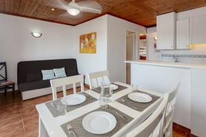 a dining room with a white table and chairs at Apartamento en complejo de zonas ajardinadas-c11 in Ciutadella