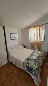 a bedroom with a large white bed and two windows at Apartmani Nika in Tribunj