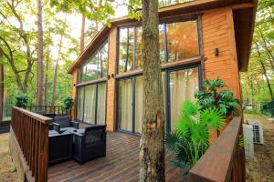 una casa con una terraza de madera con un árbol en Bizon Village en Zalesie Górne