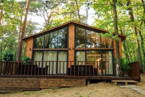 een hut in het bos met een afgeschermde veranda bij Bizon Village in Zalesie Górne