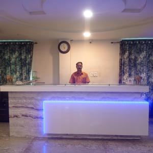 a man standing behind a counter in a room at Hotel Shubh Ashish Near Bank More in Dhanbād