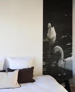a bedroom with a bed and two swans in the water at Residence9Bruges in Bruges