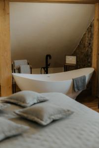 a white bath tub sitting on top of a bed at Zīles - Atpūtas komplekss in Jēkabpils