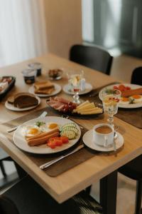 una mesa de madera con platos de desayuno. en Zīles - Atpūtas komplekss, en Jēkabpils