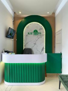 a green and white reception desk in a room at Kareem Syariah Hostel Bukittinggi in Bukittinggi