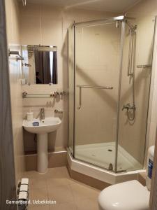 een badkamer met een douche, een wastafel en een toilet bij Maryam hotel in Samarkand