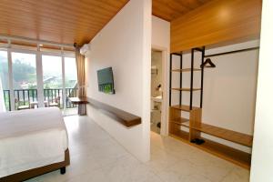 a bedroom with a bed and a balcony at Gulala Azana Hotel & Resort Guci Tegal in Tegal