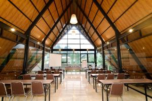 an empty classroom with tables and chairs in a building at Gulala Azana Hotel & Resort Guci Tegal in Tegal