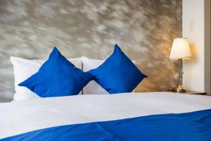 a blue and white bed with blue pillows at FDS Plaisir in Osaka