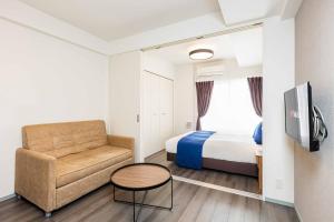 une chambre d'hôtel avec un lit et une chaise dans l'établissement FDS Plaisir, à Osaka
