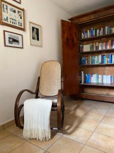 a chair in a room with a book shelf with books at Frühstückspension Haus Ebersdorf in Leiben