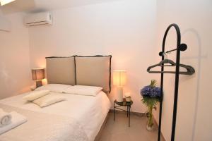 a bedroom with a bed with white sheets and two lamps at Diasof Apartments in Rome