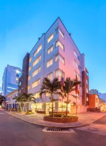 een groot gebouw met palmbomen ervoor bij Basic Hotel Centenario by Hoteles MS in Cali