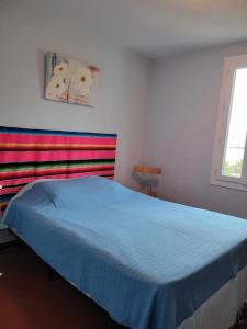 um quarto com uma cama com um cobertor azul em Maison 4 face a la mer grand Jardin Ideal Famille avec pluri Animaux Saint Clair Le Lavandou em Le Lavandou