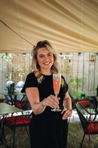 a woman in a black dress holding a glass of champagne at Boutique Hotel The Roosevelt in Middelburg