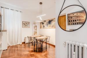 Holiday Home i Cervi في روما: غرفة طعام مع طاولة وكراسي ومرآة