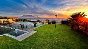 a house with a swimming pool and a view of the ocean at Heaven on Earth - Blouberg Beachfront Self-catering Apartment in Bloubergstrand