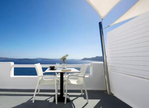 einen Tisch und Stühle auf einem Balkon mit Aussicht in der Unterkunft DAY DREAM 1 in Oia