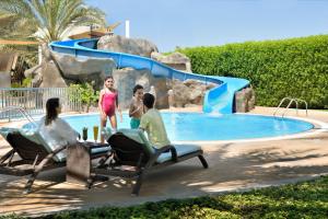 a group of people sitting in chairs in front of a water slide at InterContinental Abu Dhabi by IHG in Abu Dhabi