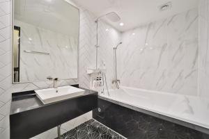 Baño blanco con lavabo y bañera en Deagu Hotel Rubato RB, en Daegu