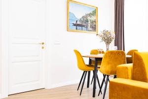uma sala de jantar com uma mesa e cadeiras amarelas em cohost I Sunny, Bright & New Apt w-Balcony @ Renesanso em Vilnius