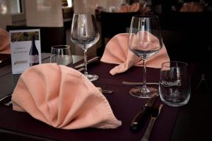 - une table avec des verres à vin et des serviettes dans l'établissement Hotel La Croix Blanche - Bassecourt, 