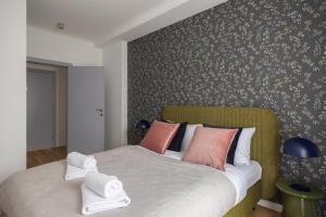 - une chambre avec un lit doté d'oreillers roses et oranges dans l'établissement Wilanów Branickiego Deluxe Apartment, à Varsovie
