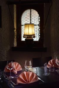 une table avec une lampe et des verres sur une table dans l'établissement Hotel La Croix Blanche - Bassecourt, 