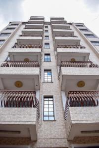 a tall building looking up at the top of it at Limpopo Suites in Nairobi