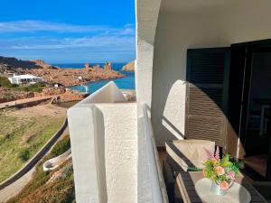 a balcony with a table and a view of the ocean at Beachfront Apartment in Cala Morell in Cala Morell +17 photos