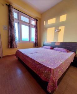 a bedroom with a large bed in a room with windows at Hotel Hill Valley, Ooty in Ooty