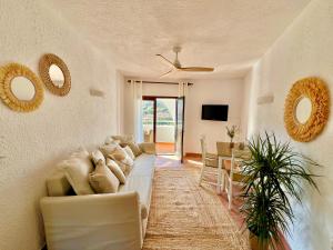 salon z białą kanapą i stołem w obiekcie Beachfront Apartment in Cala Morell w mieście Cala Morell