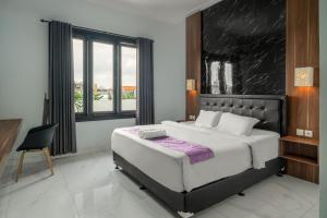 um quarto com uma cama grande e uma cadeira em Bali Dream Costel em Denpasar