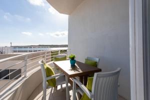 balcón con mesa y sillas en Waters-Edge Complex, en Marsaskala