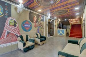 una habitación con sillas y una pared con un mural en Hi hotel By Madras, en Rishīkesh