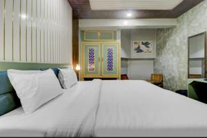 a bedroom with a large white bed in a room at Hi hotel By Madras in Rishīkesh