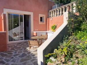 a patio with a table and chairs on a house at Les Terrasses de Lô in Bormes-les-Mimosas